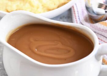 Gravy boat filled with brown gravy.
