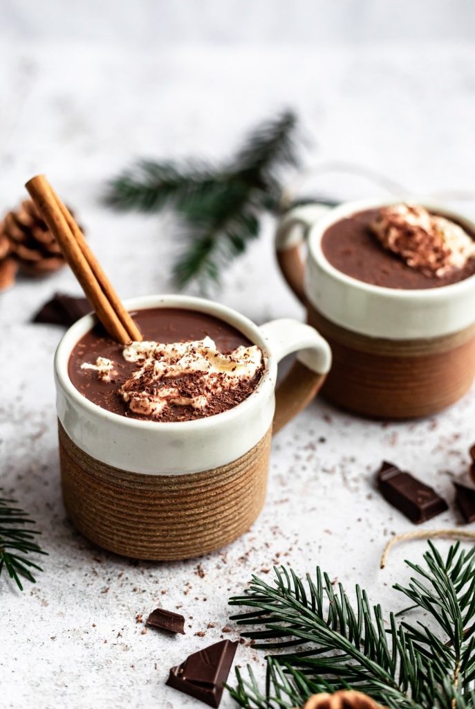 healthy hot chocolate in a mug with whipped cream an a cinnamon stick