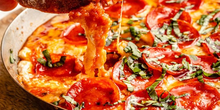 scooping pizza dip with bread