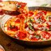 scooping pizza dip with bread