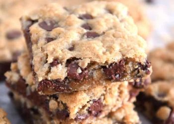 Three stacked square oatmeal chocolate chip cookie bars.