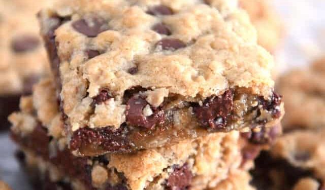 Three stacked square oatmeal chocolate chip cookie bars.