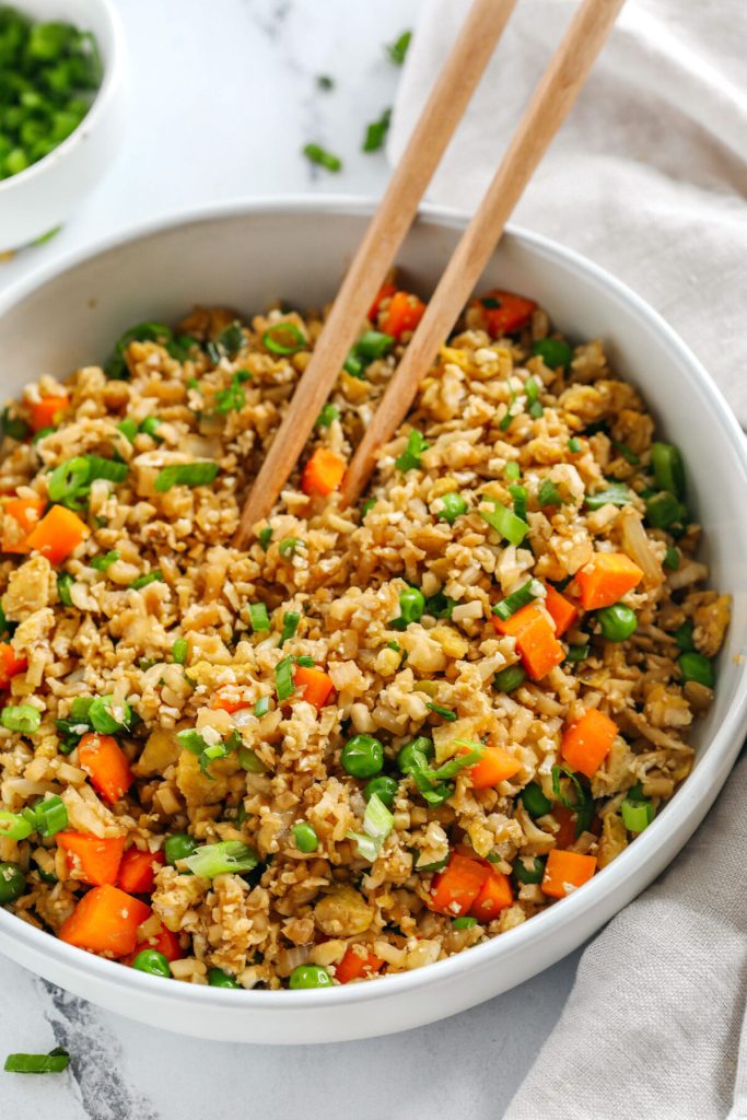 Skip the takeout and enjoy this Healthy Cauliflower Fried Rice in just 15 minutes!  Packed with veggies, low in carbs and can be served as a delicious side dish or a main dish with added protein!