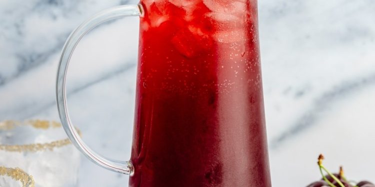 cherry lime cocktail in a pitcher