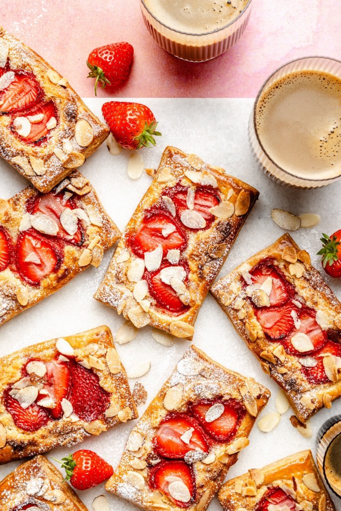 strawberry puff pastry tarts with almonds on a cutting board