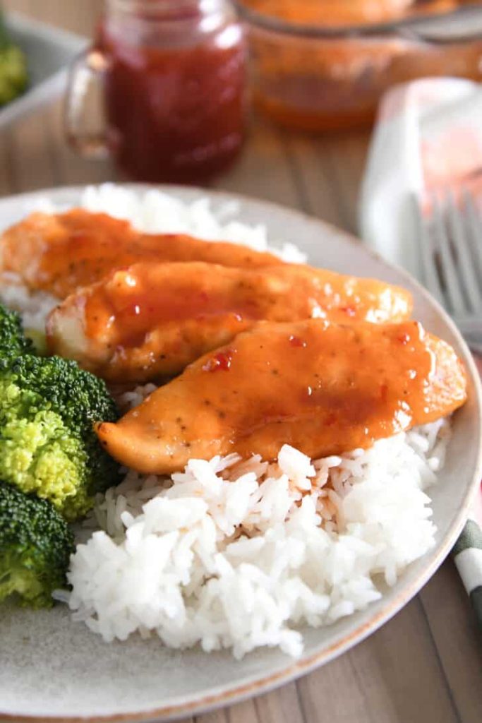 Gray plate with rice and saucy chicken tenders.