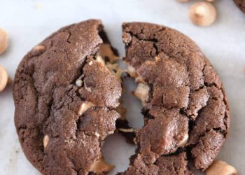 One chocolate cookie pulled in half with melty peanut butter chips.