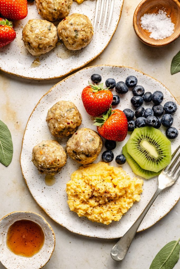 breakfast chicken meatballs on a plate with fruit and scrambled eggs