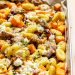 drizzling hot honey onto sheet pan butternut squash gnocchi with sausage