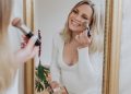 monique volz of ambitious kitchen putting pregnancy-safe skincare on her face in a mirror