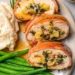 Plate with prosciutto-wrapped stuffed turkey tenderloin, green beans, and mashed potatoes.