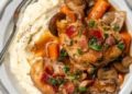 Crockpot coq au vin served over mashed potatoes.