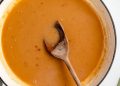 homemade turkey gravy in a pot with a wooden spoon